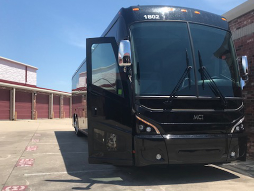 a plain black charter bus parked in a lot