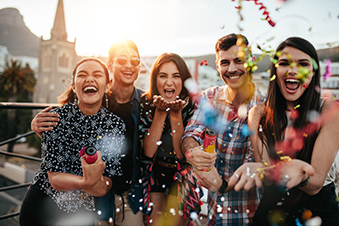Part-goers throw confetti and an outdoor event