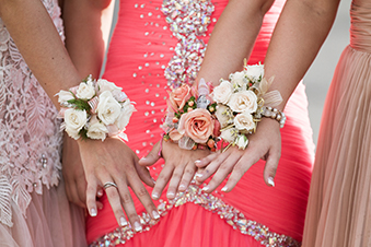 GIrls in prom dresses show off their corsages
