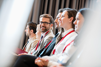 A businessman smiles during a corporate conference presentation